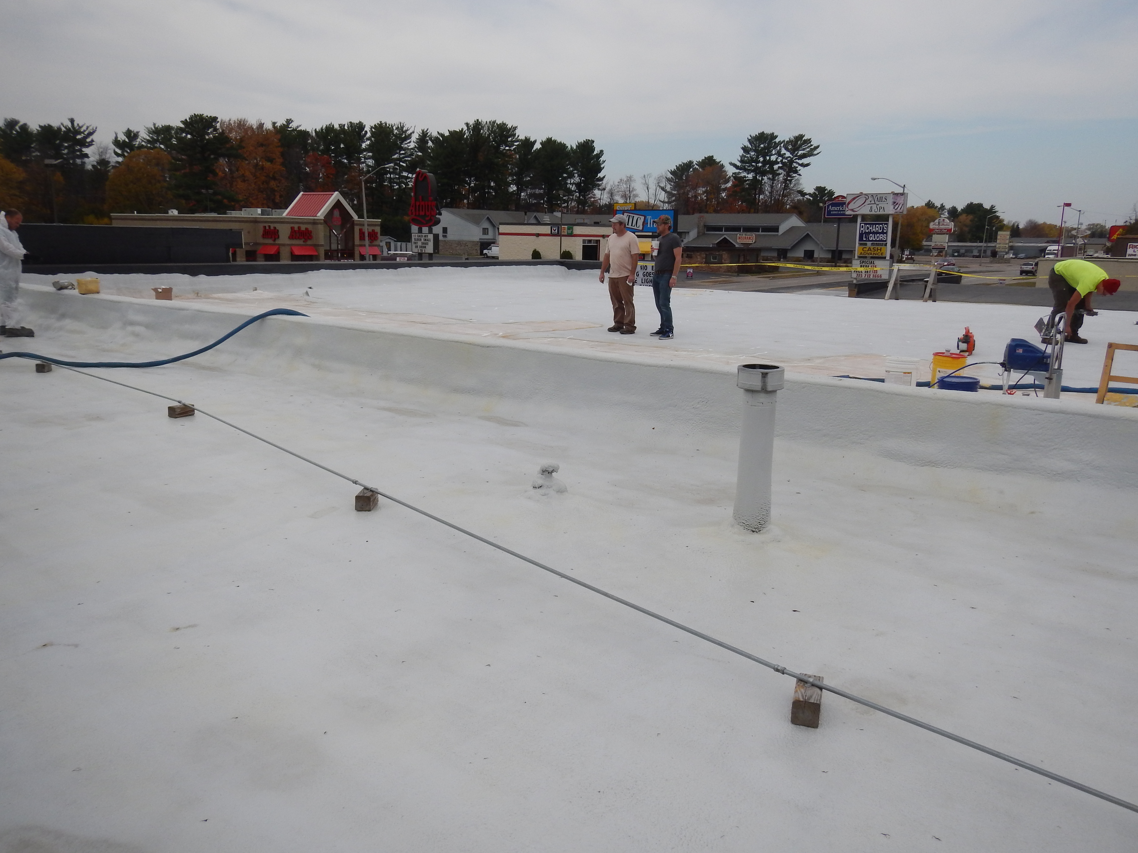 Commercial roof membrane application by spray
